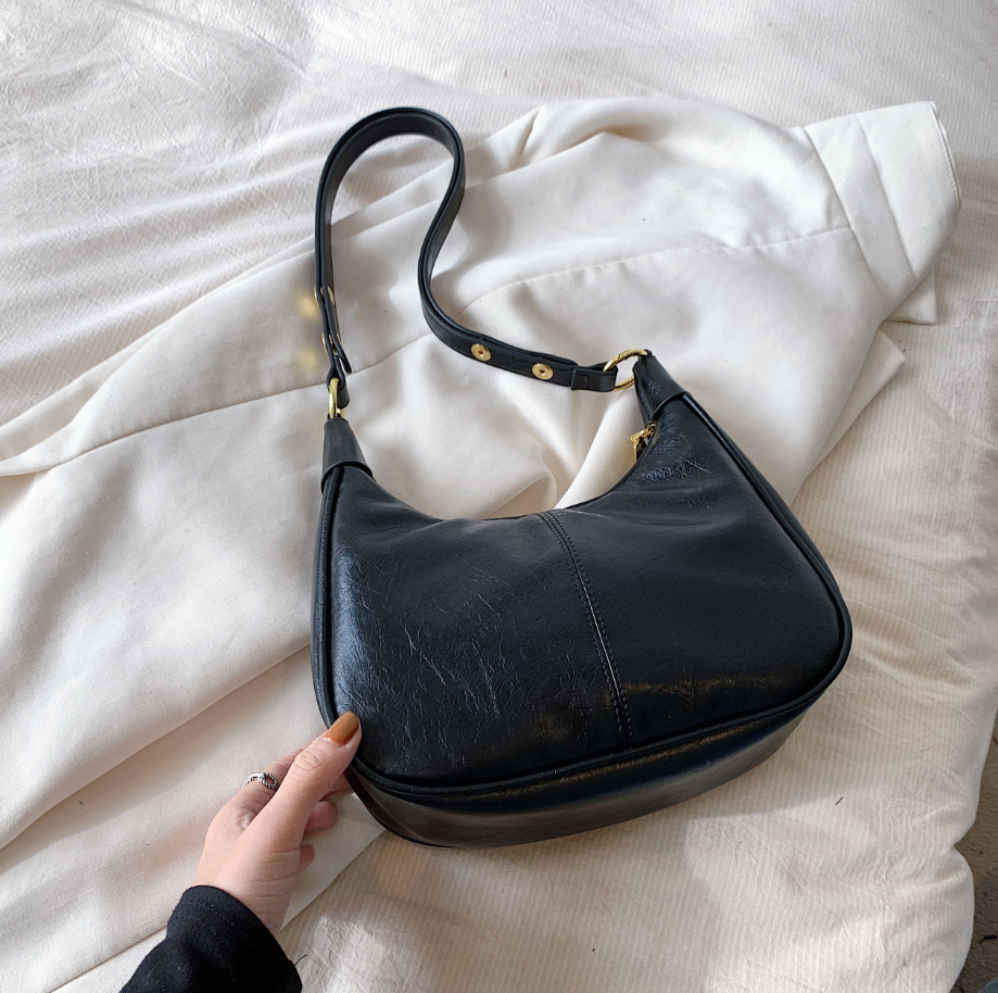 Black leather handbag on a white fabric background